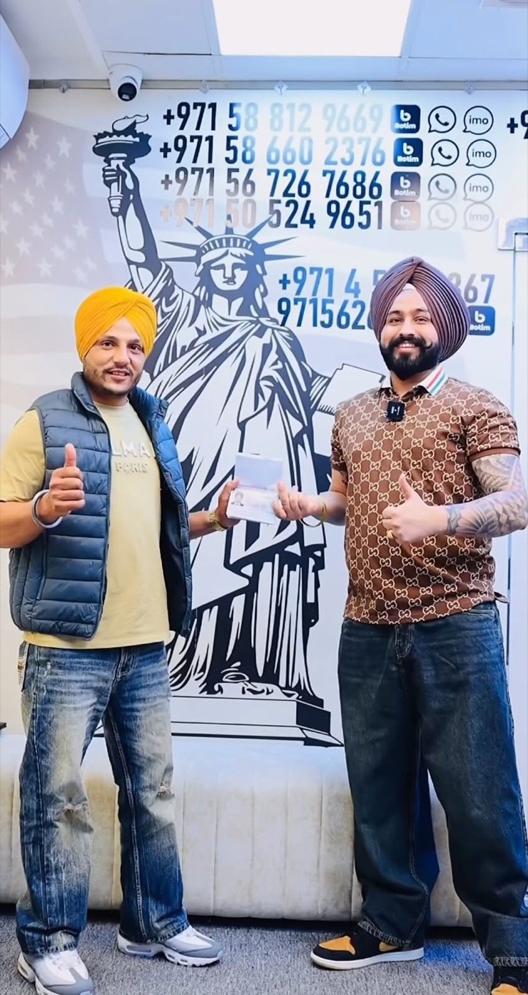 Sukhchain Travel client holding a passport at our office